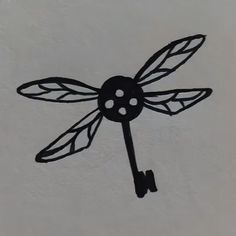 a metal clock with a dragonfly design on it's face is shown in the shape of a key