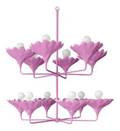 a pink and white flower arrangement hanging from a metal rod with balls in it's center