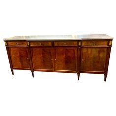 an antique sideboard with marble top and drawers