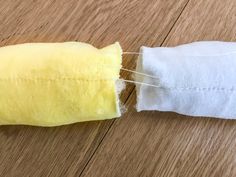 a piece of cloth is taped to the side of a roll of toilet paper on a wooden table