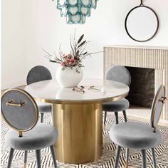 a dining room table with chairs and a chandelier hanging from the ceiling above it