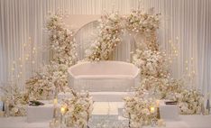 a white wedding setup with flowers and candles