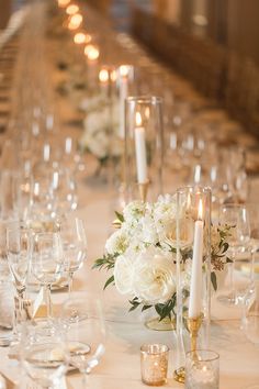 a long table with white flowers and candles