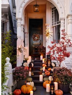 a front porch with candles and pumpkins on the steps