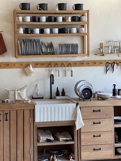 the kitchen is clean and ready to be used for cooking or baking, with dishes stacked on shelves above the sink