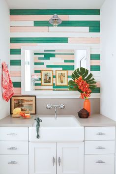 a white sink sitting under a bathroom mirror next to a wooden paneled wall with pictures on it