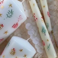 three candles sitting on top of a table next to a white plate with christmas decorations