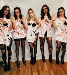 four women dressed up in halloween costumes posing for a photo with their hands on their hipss