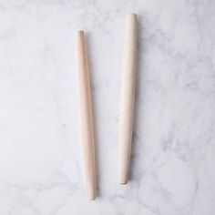 two wooden spoons sitting next to each other on a marble surface