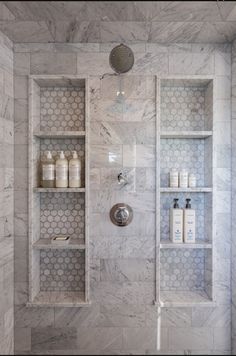 a bathroom with marble walls and shelves in it