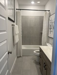 a bathroom with a toilet, sink and bathtub next to a shower curtained window