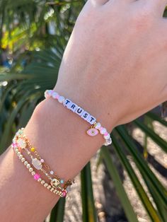 a woman's arm with two bracelets on it and the word trust written in small letters