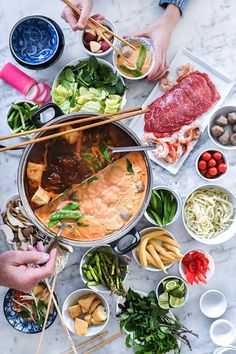 a table topped with lots of food and chopsticks