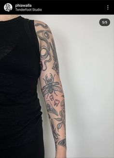 a woman's arm with tattoos on it, and an insect in the middle