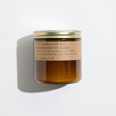 a jar of honey sitting on top of a white table next to a brown label