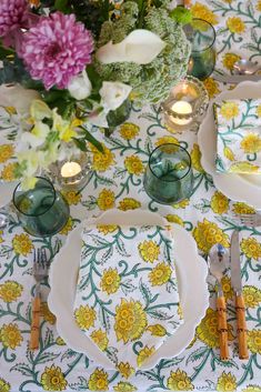 the table is set with flowers and candles