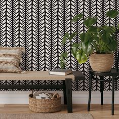 a black and white patterned wallpaper next to a bench with a plant on it