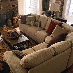 a living room filled with furniture and a fire place in front of a brick fireplace