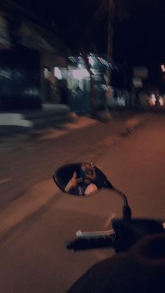 a person is taking a picture in the mirror of a motorbike at night