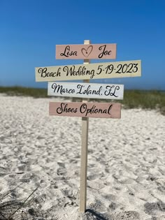 a beach wedding sign on the sand