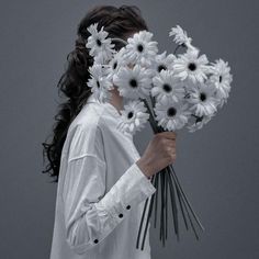 a woman holding a bunch of white flowers