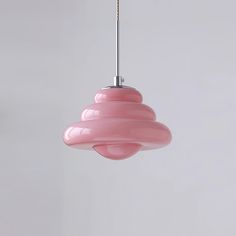 a pink light fixture hanging from a ceiling