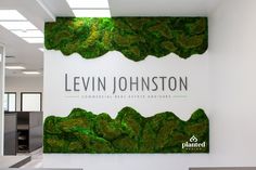 the sign for levin johnston commercial real estate advisory is covered in green moss