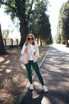 My new favorite athleisure outfit - these green leggings are so flattering and comfortable - size XS (about 90% as good as Lululemon, seriously). This white long sleeve tee is thick in the best way - no bra lines. I have a small in the tee and the cream vest as well. #FallAthleisure #GreenLeggings #PufferVestOutfit #FallOutfit Plain Long Sleeve Outfit, Styling Green Leggings, Hunter Green Leggings Outfit, Outfit With Green Leggings, Athleta Leggings Outfit, What To Wear With Green Leggings, Style Green Leggings, Mint Leggings Outfit, How To Style Green Leggings