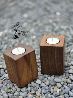 two wooden candles are sitting on some rocks