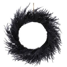 a black wreath hanging on a white wall