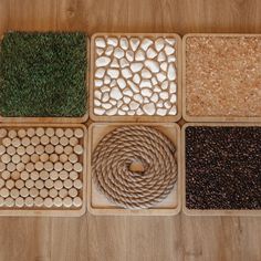 four trays filled with different types of seeds and grass on top of a wooden table