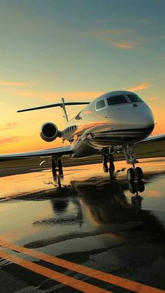 an airplane is sitting on the tarmac at sunset with its landing gear still down