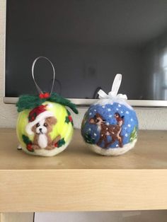 two christmas ornaments are sitting on a shelf