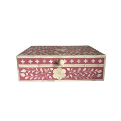 a pink and white box with flowers painted on the lid, sitting against a white background