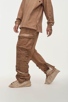 The Distressed Multi-Pocket Layered Cargo Pants in Earth perfectly merge street style with practicality. These cargo pants feature multiple flap pockets on both sides, providing ample storage and a rugged look. The elasticized cuffs create a natural stacking effect when worn, while zippers on the cuffs allow for an adjustable fit around the calves, enhancing mobility. The washed, distressed finish adds a unique edge to the design. Made from premium 100% cotton fabric, these slightly oversized pa Techwear Wide Leg Cargo Pants With Patch Pockets, Techwear Cotton Cargo Pants With Flap Pockets, Streetwear Full-length Cargo Jeans With Patch Pockets, Streetwear Full Length Cargo Jeans With Patch Pockets, Techwear Wide Leg Cargo Pants With Multiple Pockets, Wide Leg Techwear Cargo Pants With Multiple Pockets, Utility Cargo Pants With Flap Pockets, Urban Cargo Pants With Pockets, Baggy Cargo Jeans With Patch Pockets For Outdoor