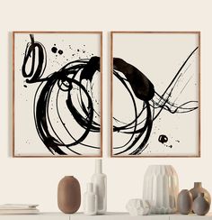 two black and white paintings hanging on a wall