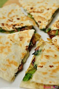 several quesadillas cut in half on a white plate