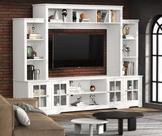 a living room with a large entertainment center and brick wall in the backround