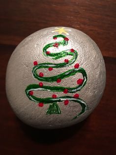 a painted rock with a christmas tree on it