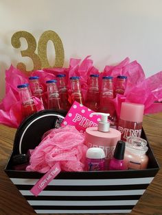 a black and white box filled with lots of pink items on top of a wooden table