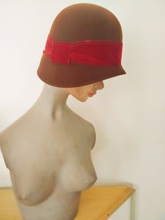 Merino wool felt cloche, 1920s period, asymmetrical with decorative red velvet band. In the 1920s, the cloche hat trend was launched by the French milliner Caroline Reboux. Winter Flapper Style Brimmed Cloche Hat, Adjustable Cloche Hat In Flapper Style, Red Velvet Band, Flapper-style Brimmed Cloche Hat For Party, Vintage Black Cloche Hat, 1920 Style, Flapper Cloche, 1920's Flapper, 1920 Fashion