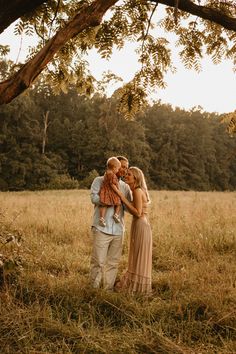 a family standing under a tree in an open field