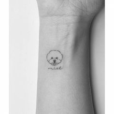 a small black and white dog tattoo on the left wrist, with an outline of a poodle's head