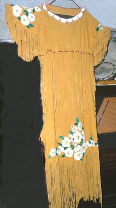 Handgemachtes Cherokee Rose Leder Kleid ist aus weichen Hirschhäuten mit vielen Fransen.  Jede einzelne Rosenblüte und blatt wird einzeln von Hand perlengestickt und anschließend unabhängig voneinander mit Künstlichem Sinew für einen sicheren Sitz aufgenäht. Hergestellt aus drei goldenen Hirschhäuten, jeder Fransen wird individuell von Hand geschnitten. Seitliche Schnürung geben etwas Flexibilität in der Breite; Halsausschnitt ist weißes Hirschfell, beschnitten mit roten Glas-Saatperlen.  Blumen Cherokee Rose, Cherokee Dress, Golden Deer, Native Dress, Deer Hide, White Deer, Native American Beading, Glass Seed Beads, Leather Dress