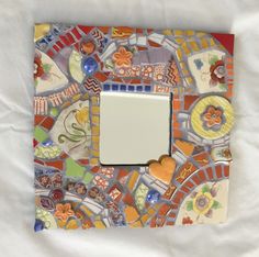 a mosaic tile photo frame with a heart on the front, and a small mirror in the middle