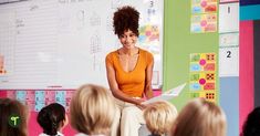 a woman standing in front of a group of children