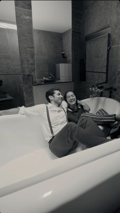 a man and woman laying in a bathtub