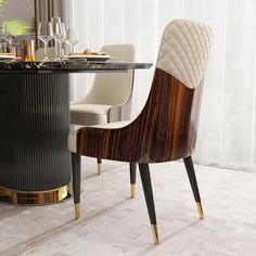 a dining room table and chairs with wine glasses on the top, next to a glass vase filled with flowers