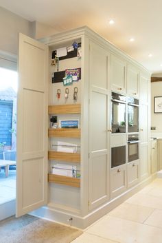 a kitchen with white cabinets and an open door leading to the outside patio area,