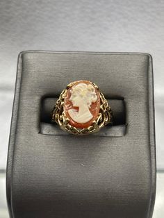 This ring is made in 10 karat yellow gold in a beautiful open scroll design work with a striking cameo on top.  The cameo is carved with amazing detail.   Weight:  4.1 grams Ring Size:  6 ¼  Our Price $425.00 Regularly Priced At $675.00 Please See Our Video Remember - If you're purchasing for yourself or a gift for a loved one, buy with confidence.  We Guarantee Everything We Sell!  SKU # R927 Classic Oval Cameo Rings, Formal Oval Engraved Ring With Intaglio, Oval Engraved Ring With Intaglio For Formal Events, Yellow Gold Cameo Ring Fine Jewelry, 14k Gold Cameo Ring, Cameo 14k Gold Ring, 14k Gold Cameo Ring Fine Jewelry, Cameo 14k Gold Rings For Collectors, 14k Gold Cameo Rings For Collectors